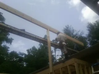 Carpenter setting a ridge beam over a new addition frame — Ice Dam Removal by Roofing Brothers in Cuthbert