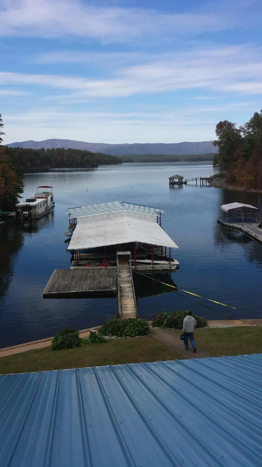 View across a lake from a newly installed blue metal roof in Cuthbert
