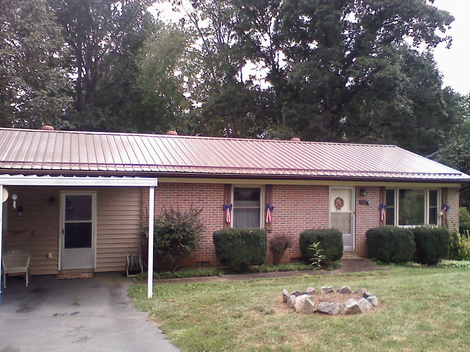 Bronze metal roof and carport on a brick ranch home — Roof Repair work by our crew in Cuthbert